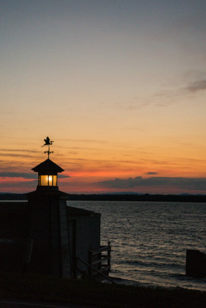 View of Lake Champlain at sunset with boat house light