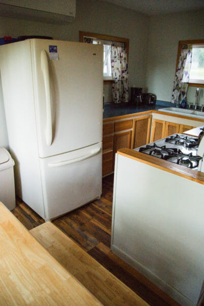 Interior of Airbnb in Plattsburgh, NY of kitchen with white fridge and wooden cabinets