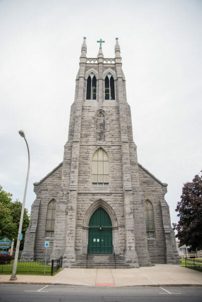 Grey stone church with green doors in Plattsburgh, NY