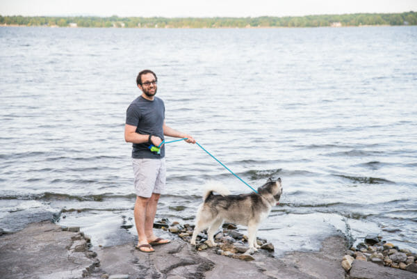 Man and Siberian Husky next to lake