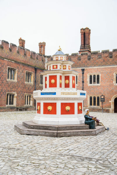 Tall red water fountain in the courtyard of Hampton Court