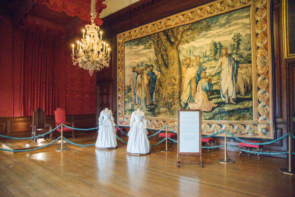 Tapestry room with a chandelier and mannequins in ballgowns in Hampton Court