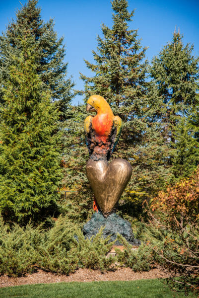 Large parrot on a heart statue at Meijer Gardens