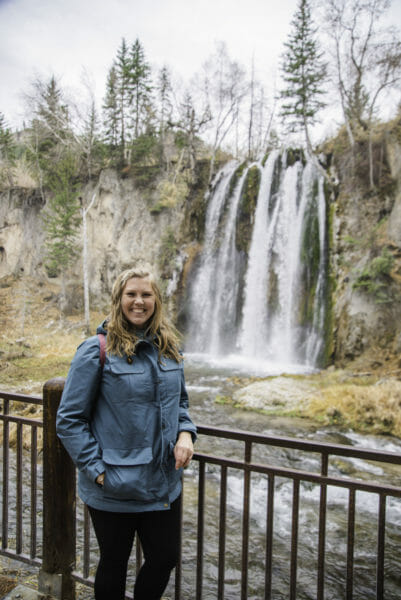 Woman standing in front of waterfall in the Black Hills