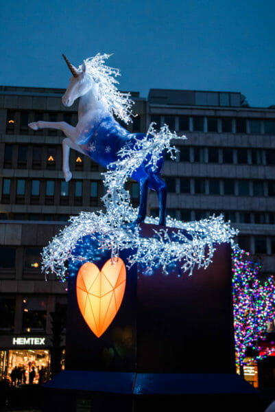 Blue unicorn with a yellow heart lit up at night